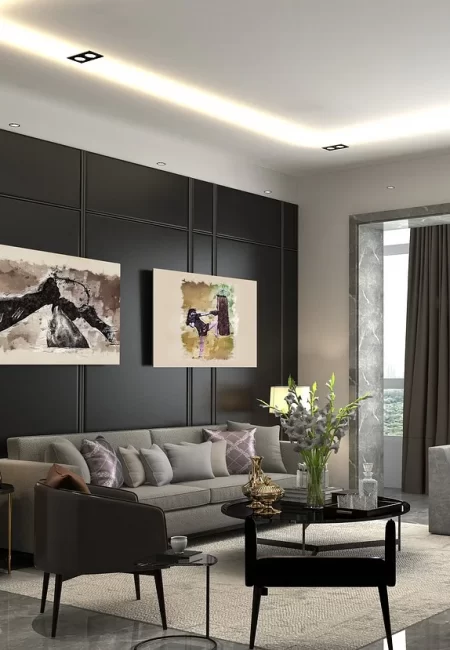 Modern gray sofa with plush cushions in a contemporary living room with dark walls and abstract art